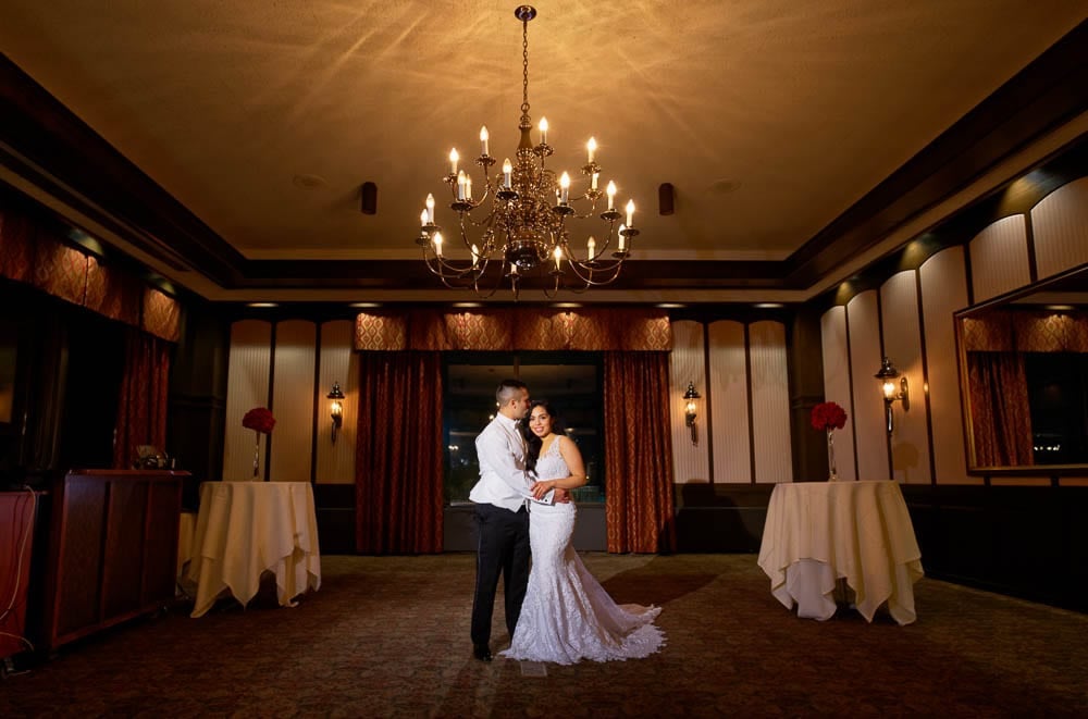 majestic shot of bride and groom with chandelier in ample halls