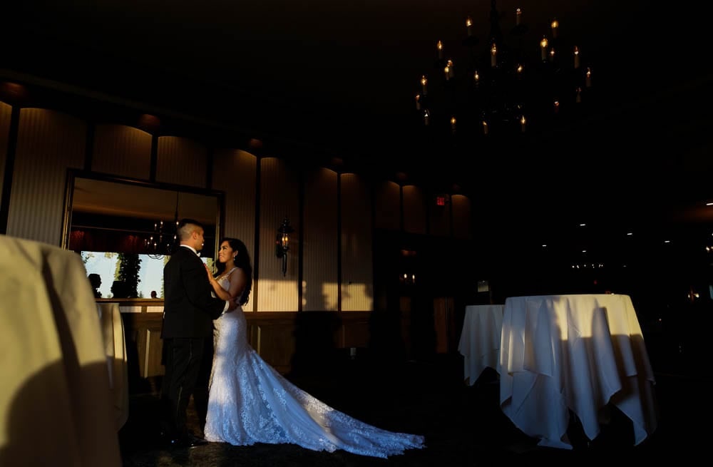 newlywed gazing each other with natural light and crystal chandelier