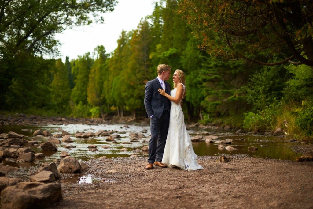 bride and groom in front of the river