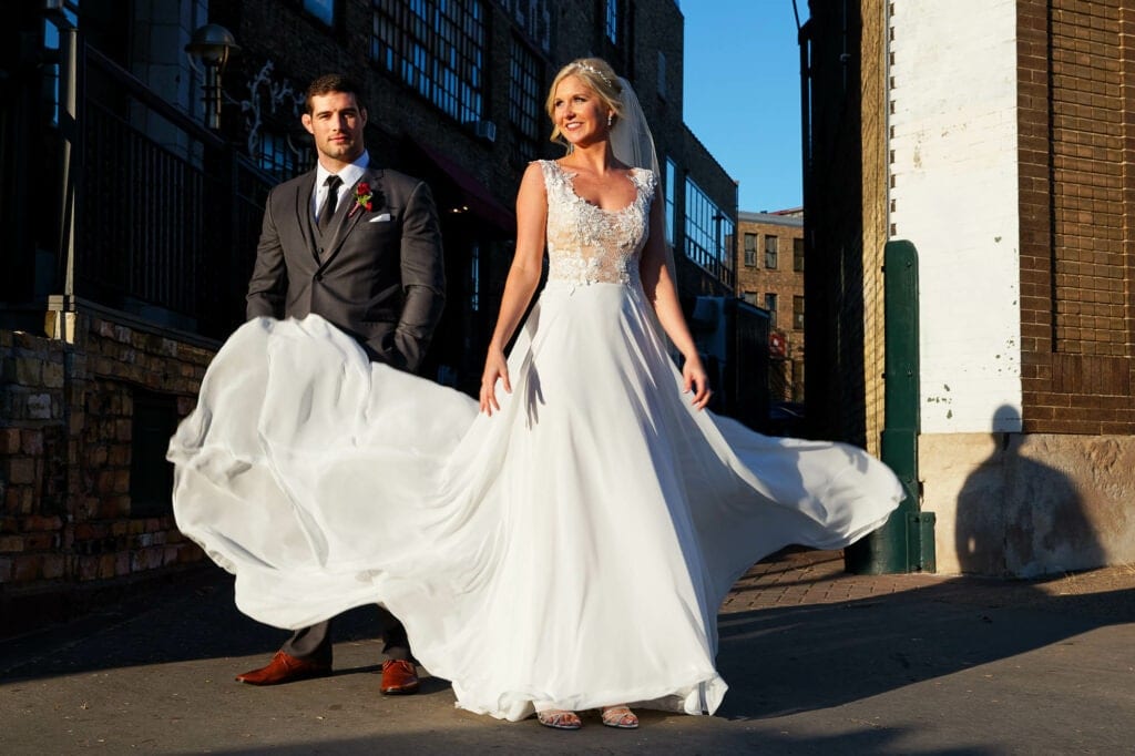 bride playing with her dress in old industiral street