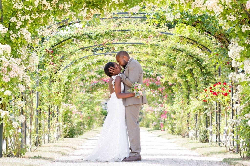 bride and groom kissing in a rose garden