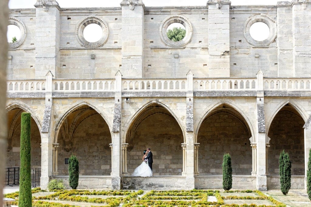 newlyweds hugging in an abbey arches