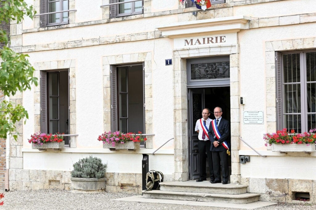 the mayor of the village and his assistant waiting for the guests to enter