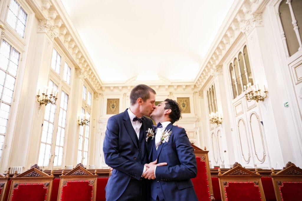 newly married same sex couple kissing in the celebration room