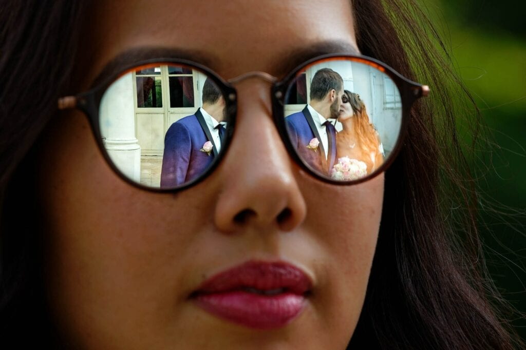 reflexion on sun glasses of the bride and groom kissing