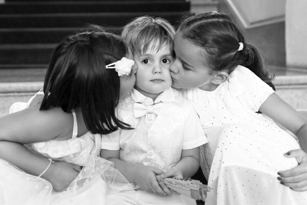 lucky boy being kissed on the cheecks by two girls