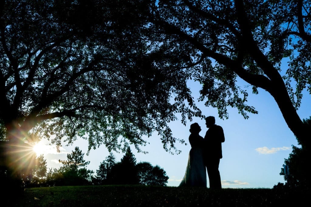 bride and groom silhouette with tree and sunset