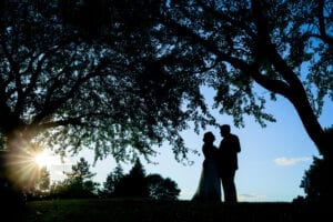 bride and groom silhouette with tree and sunset