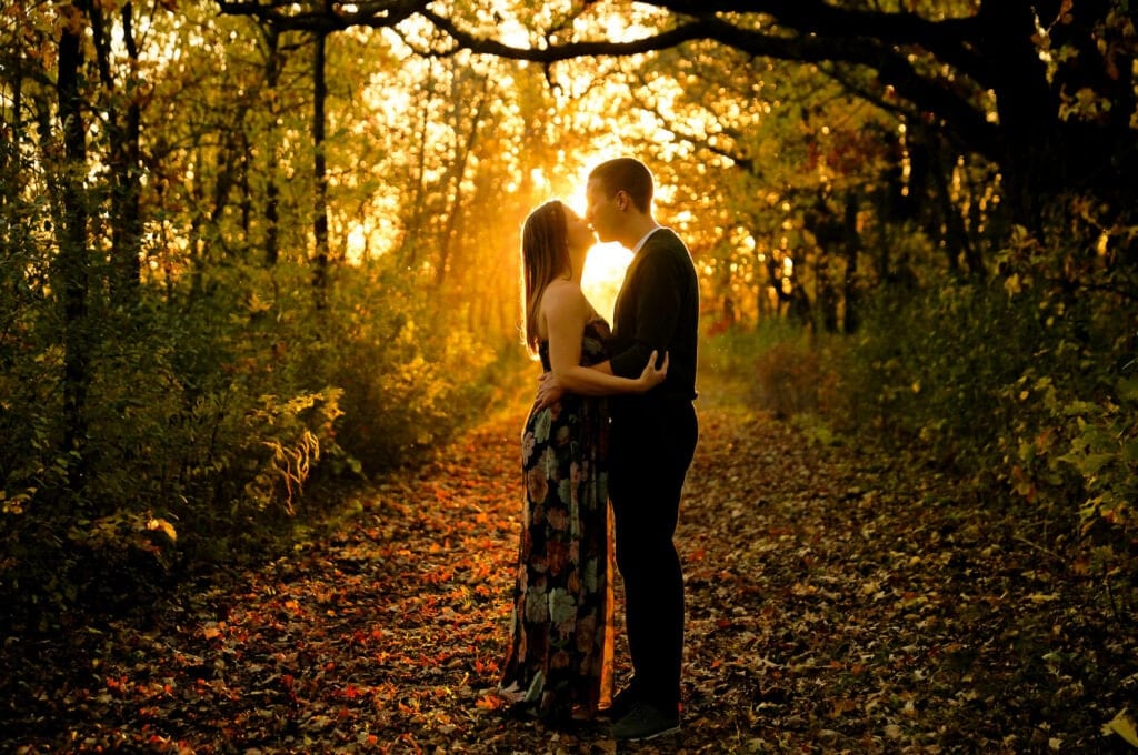 couple in love kissing in the woods falls seasons engagemetn session