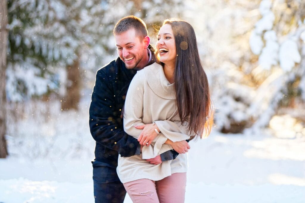 couple holding hands and kissing in meadow