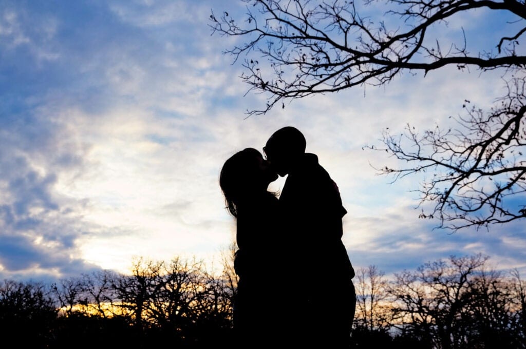 meet cute couple kissing in silhouette portrait