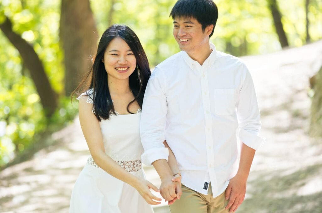 couple hold hands at minnehaha falls