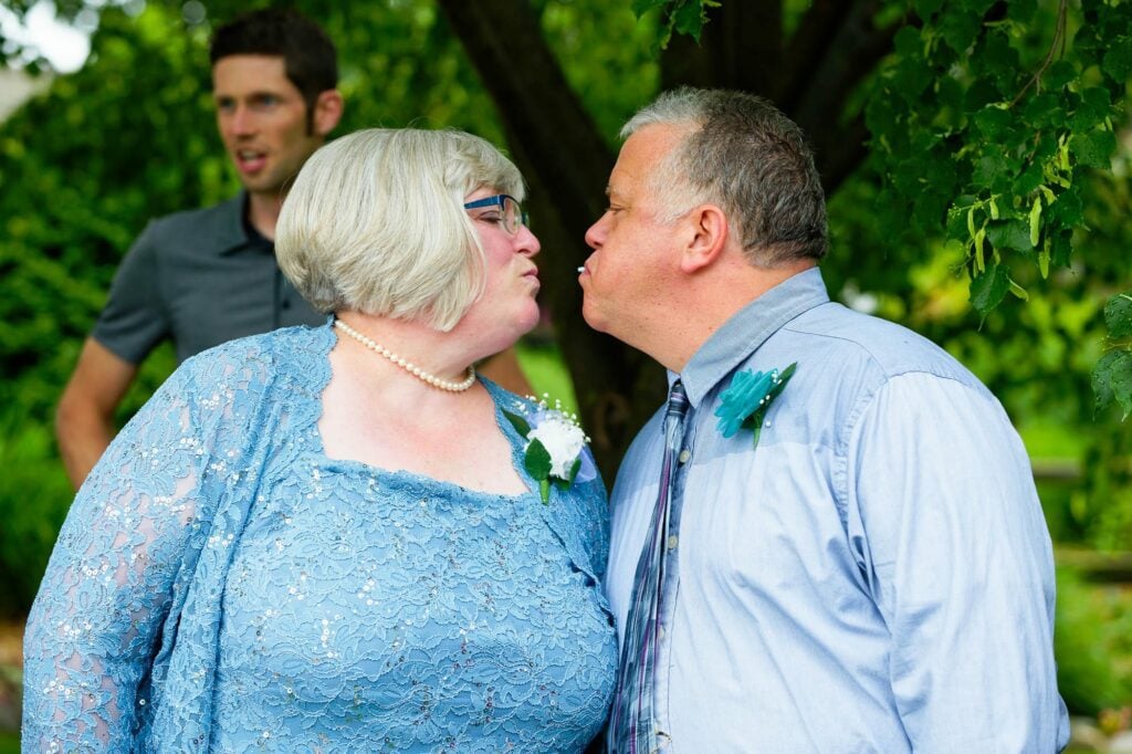 parents of the groom exchanging more than a kiss