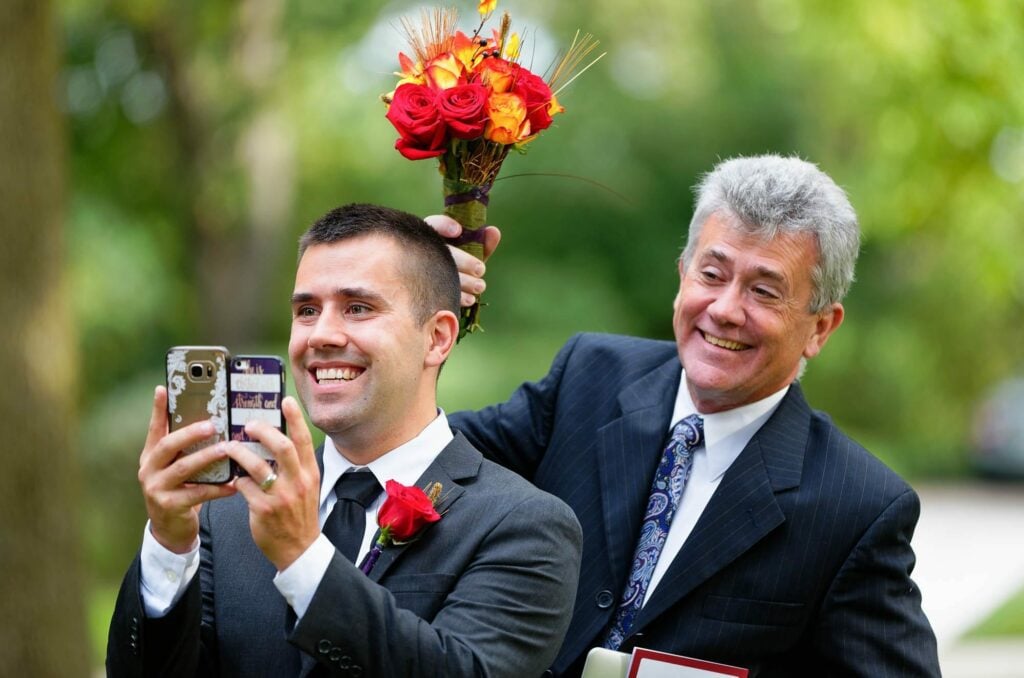 uncle making fun of his fun during group pictures