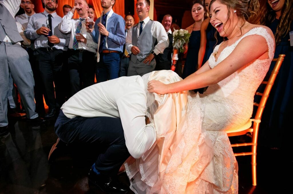 groom getting the garter with his teeth