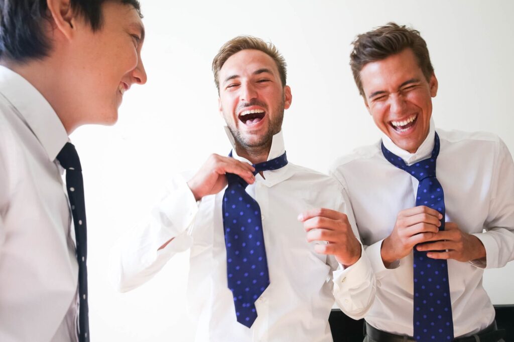 groom and groom's men having fun with ties