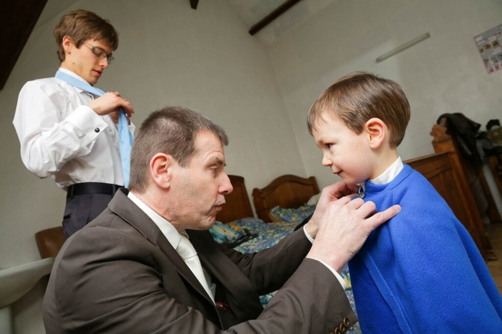 father of the groom attaching the nephew cap