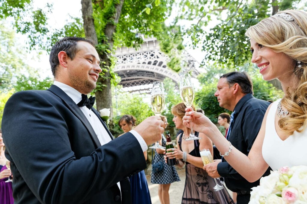 bride and groom toasting eiffel tower