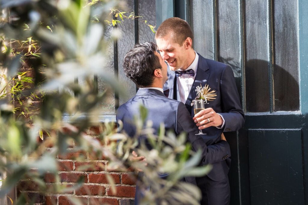 same sex wedding couple drinking champagne