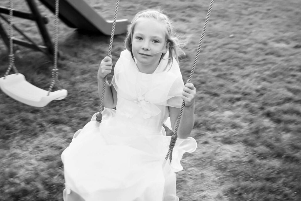 flower girls playing on a swing