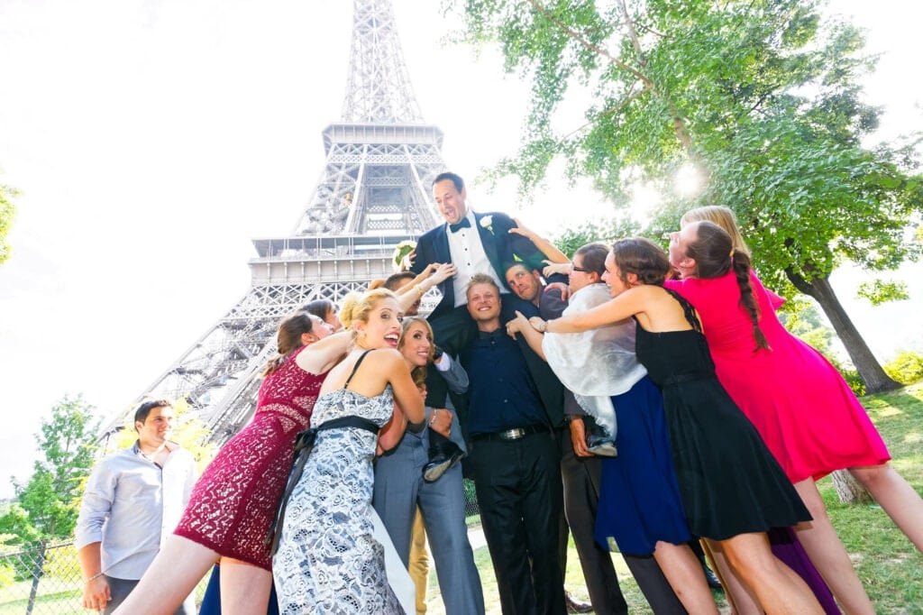 friends carring the groom in front of the effeil tower