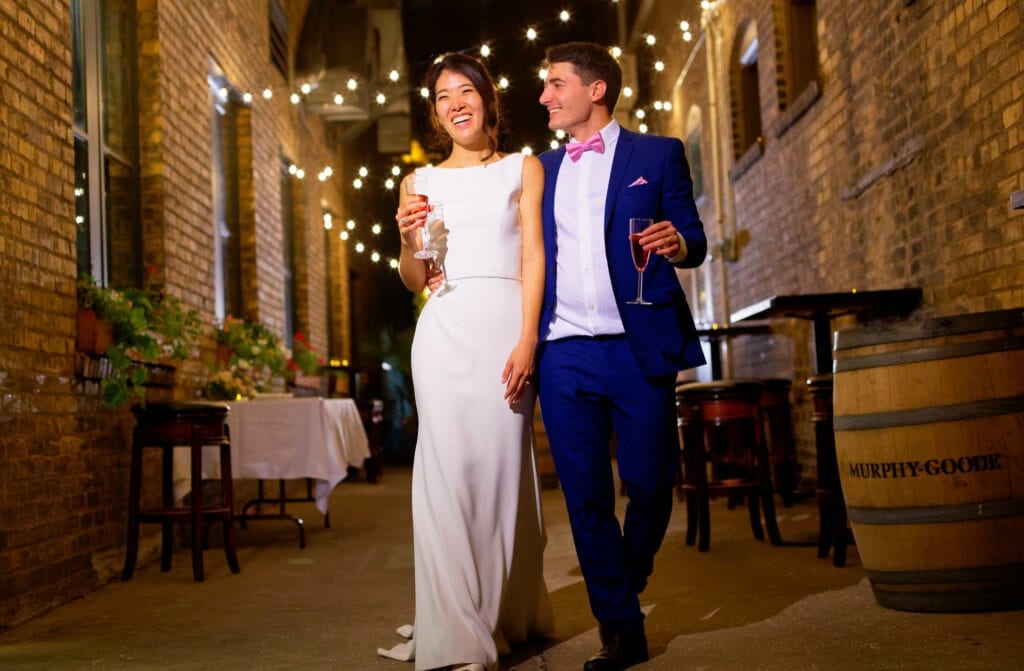 bride and groom walking in red brick street