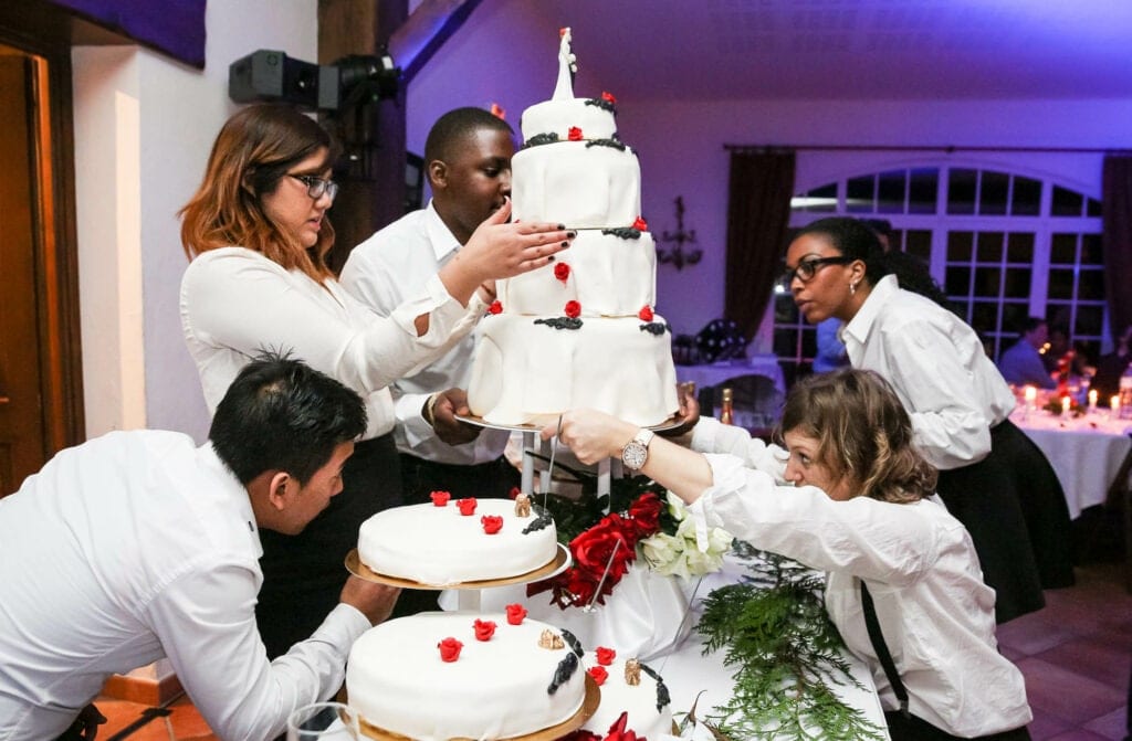 five waiter stuggling with one cake