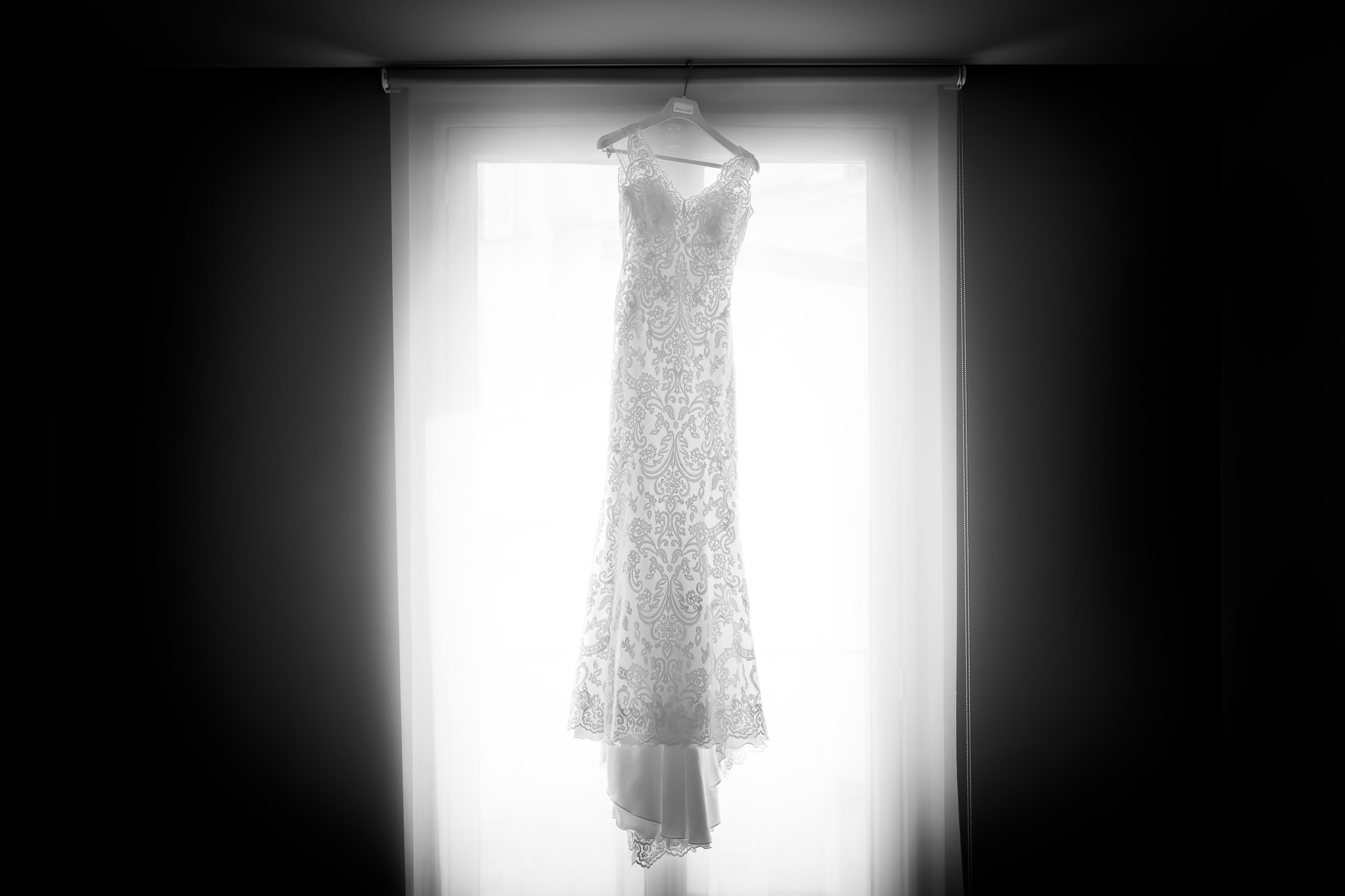 Wedding Dress Hanging in Window During Bridal Preparation