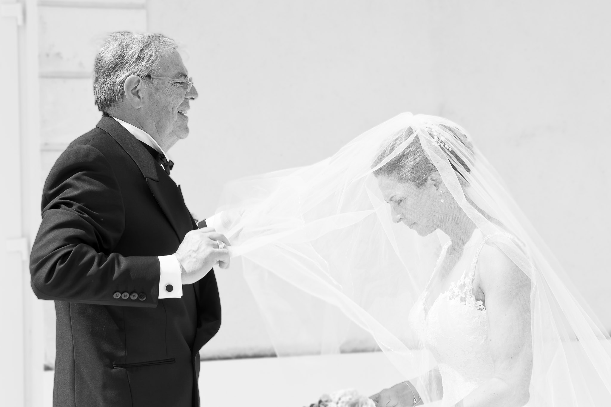 Father Helping Bride with Veil During First Look Wedding Moment