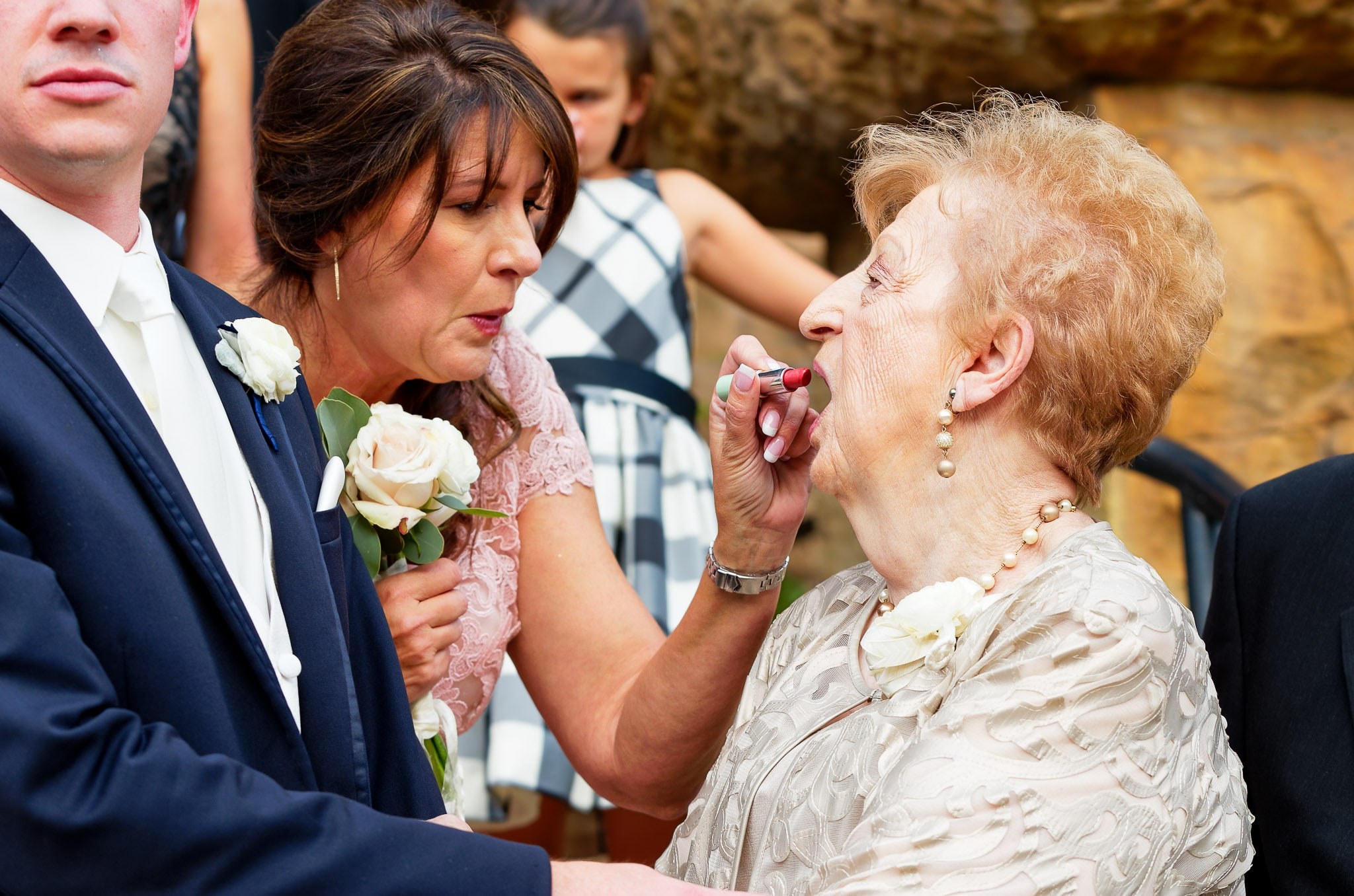 Mother Helping Grandmother with Lipstick During Wedding Photos