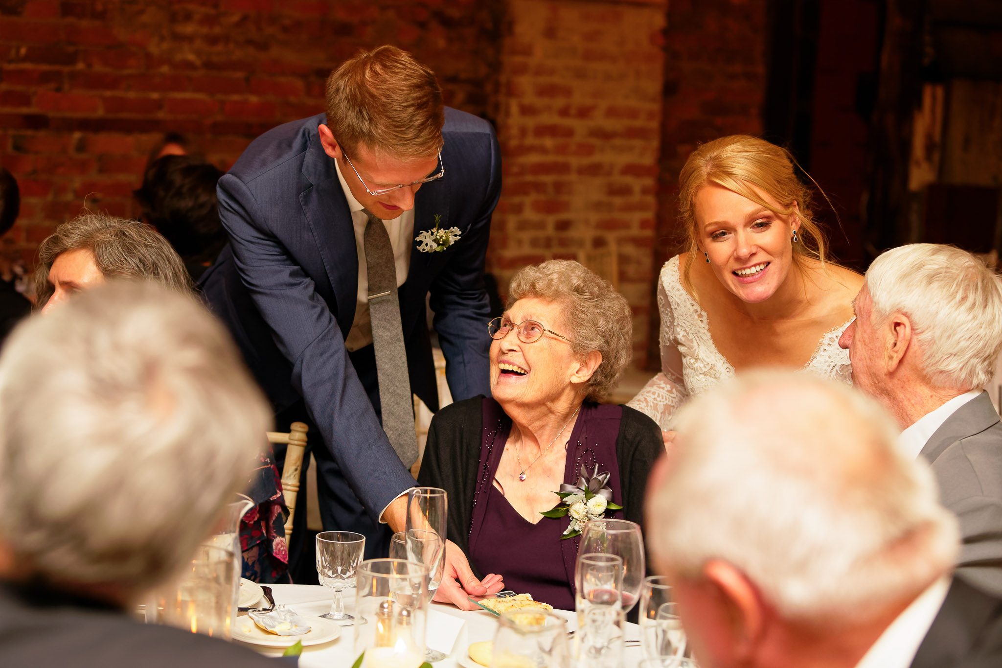 Bride and Groom Serving Dessert to Grandmother at Reception