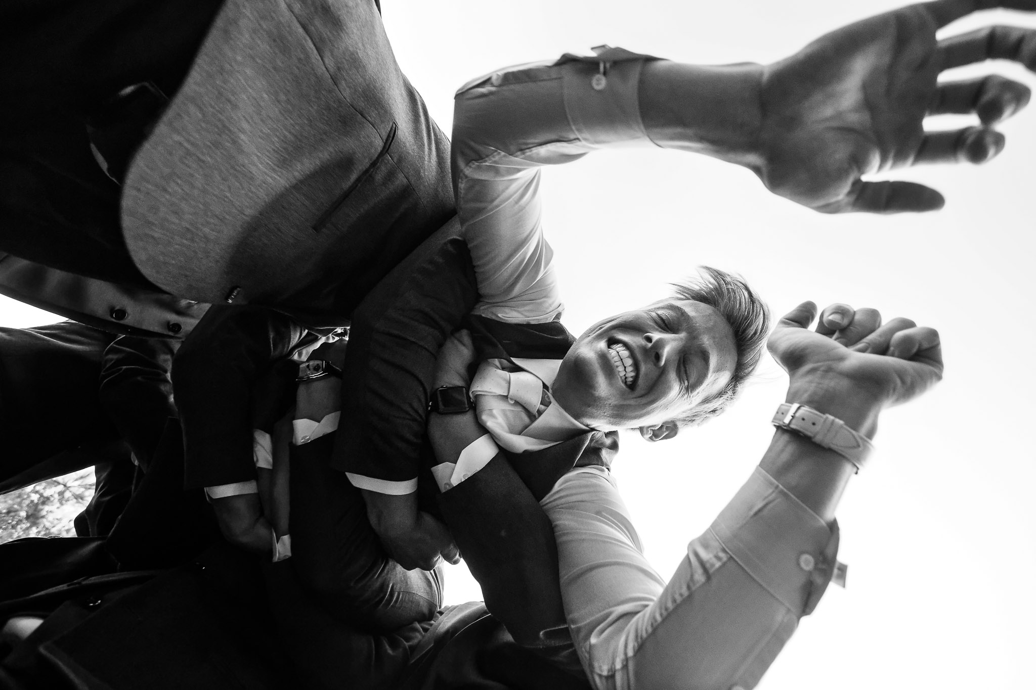 Groomsmen Lift Groom in Air During Wedding Celebration