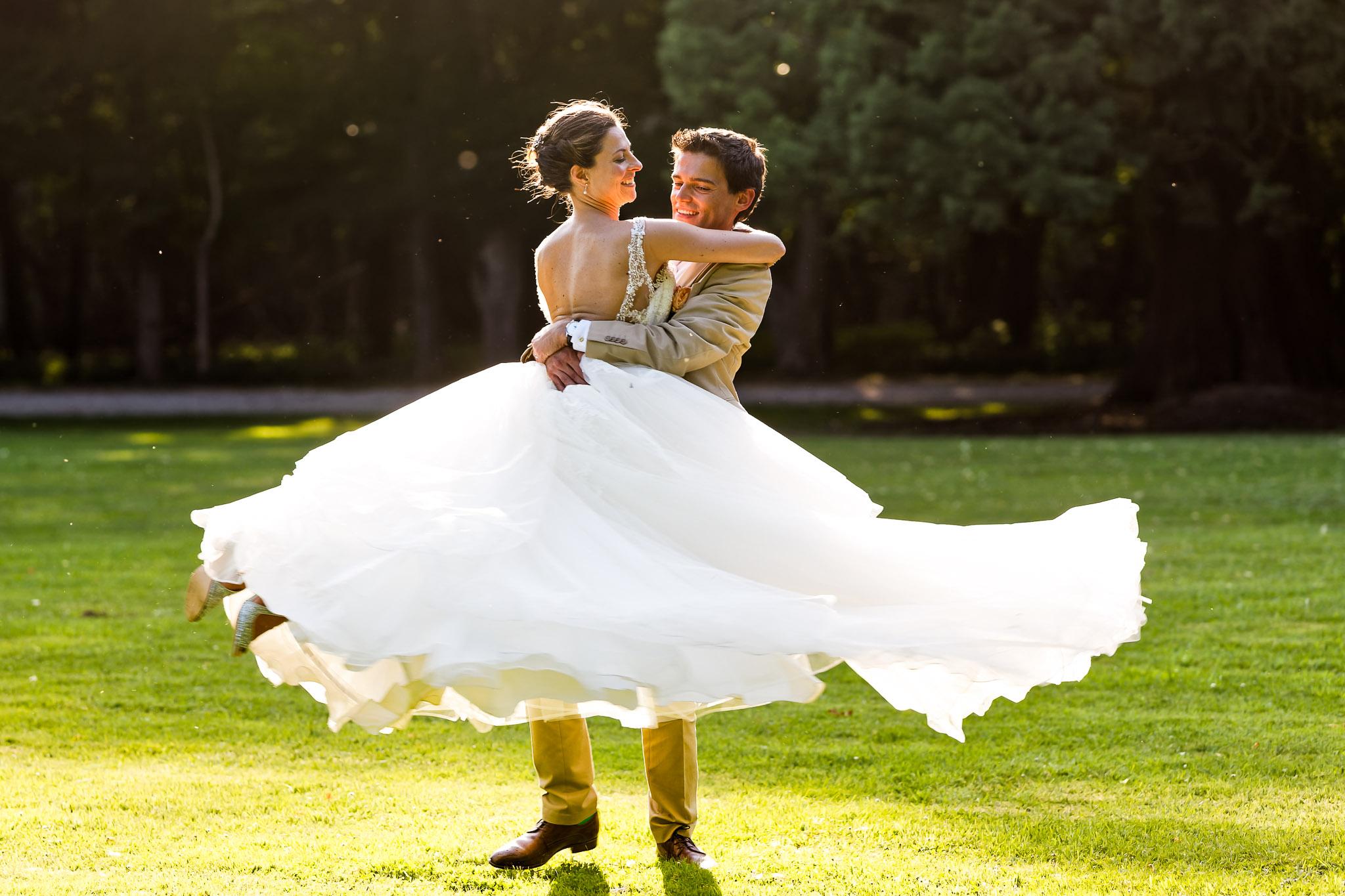 Groom Spinning Bride Wedding Portrait in Golden Sunlight