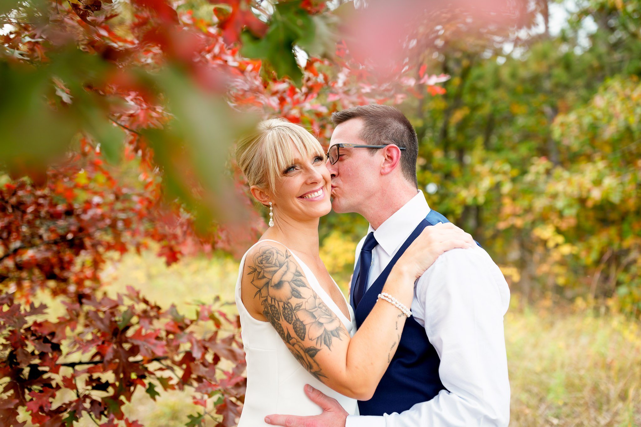 Fall Wedding Portrait - Bride and Groom Kiss in Autumn Leaves