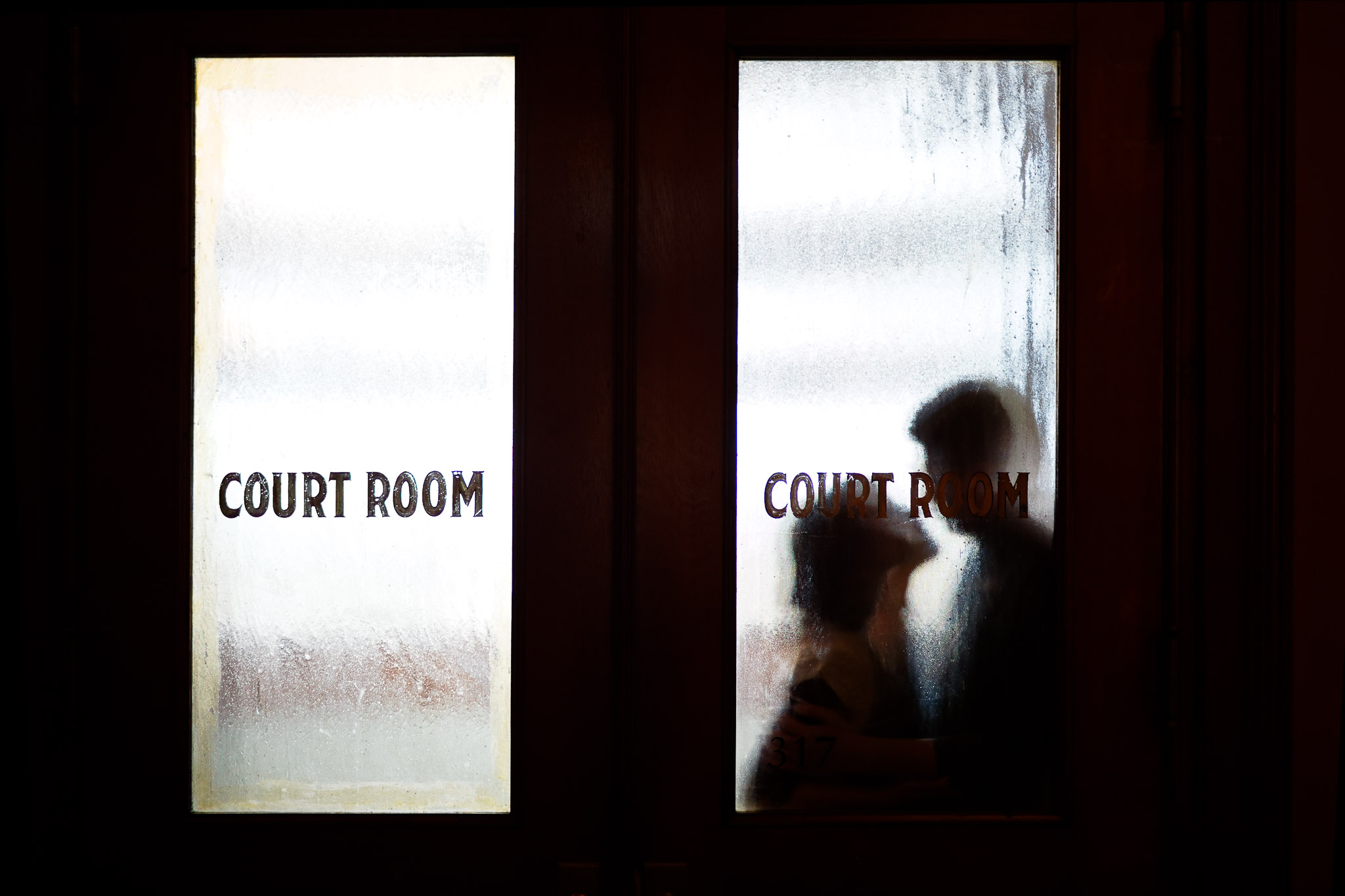 Courthouse Wedding Kiss Through Glass Doors