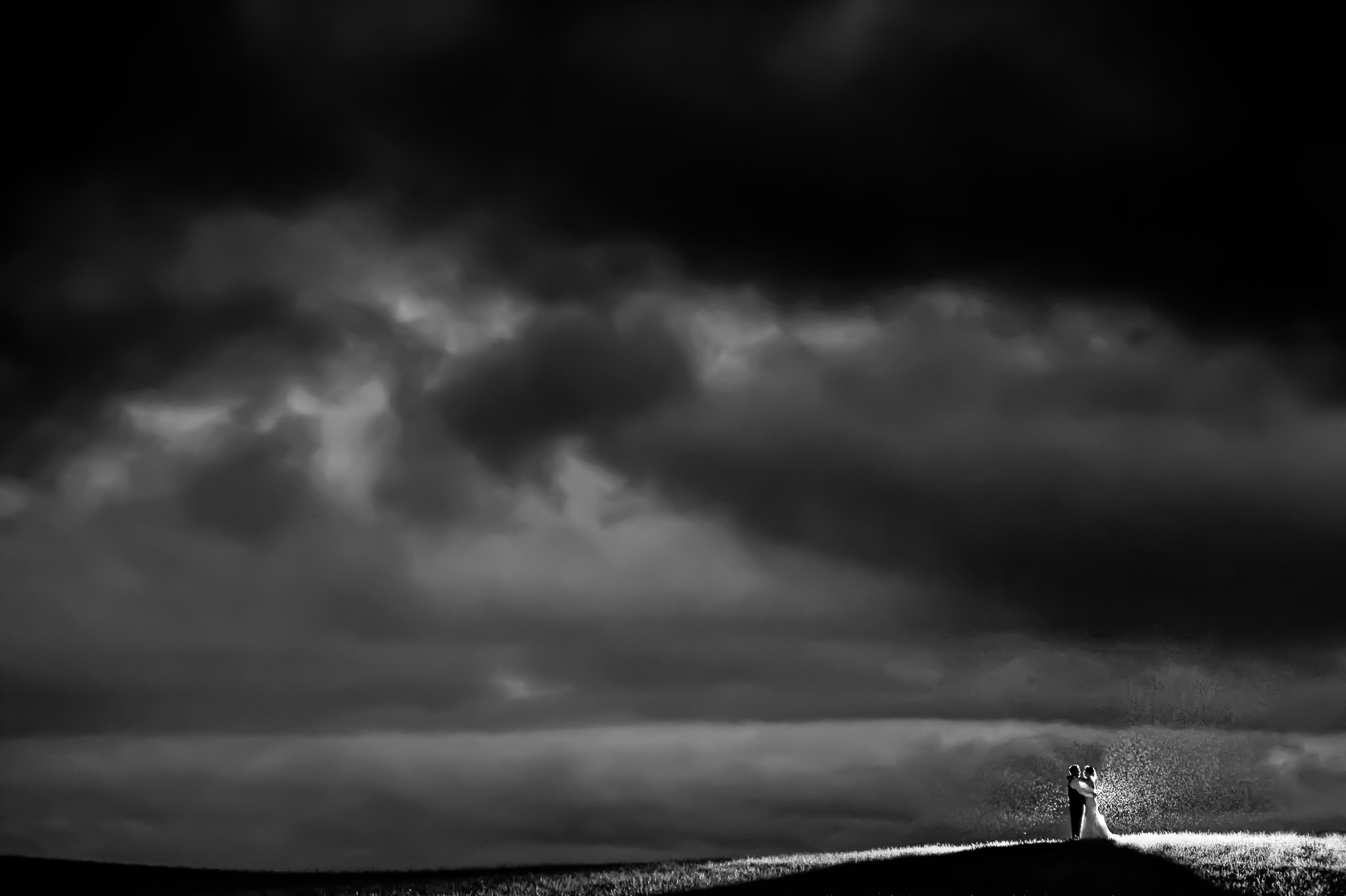 Dramatic Hilltop Wedding Portrait with Storm Clouds