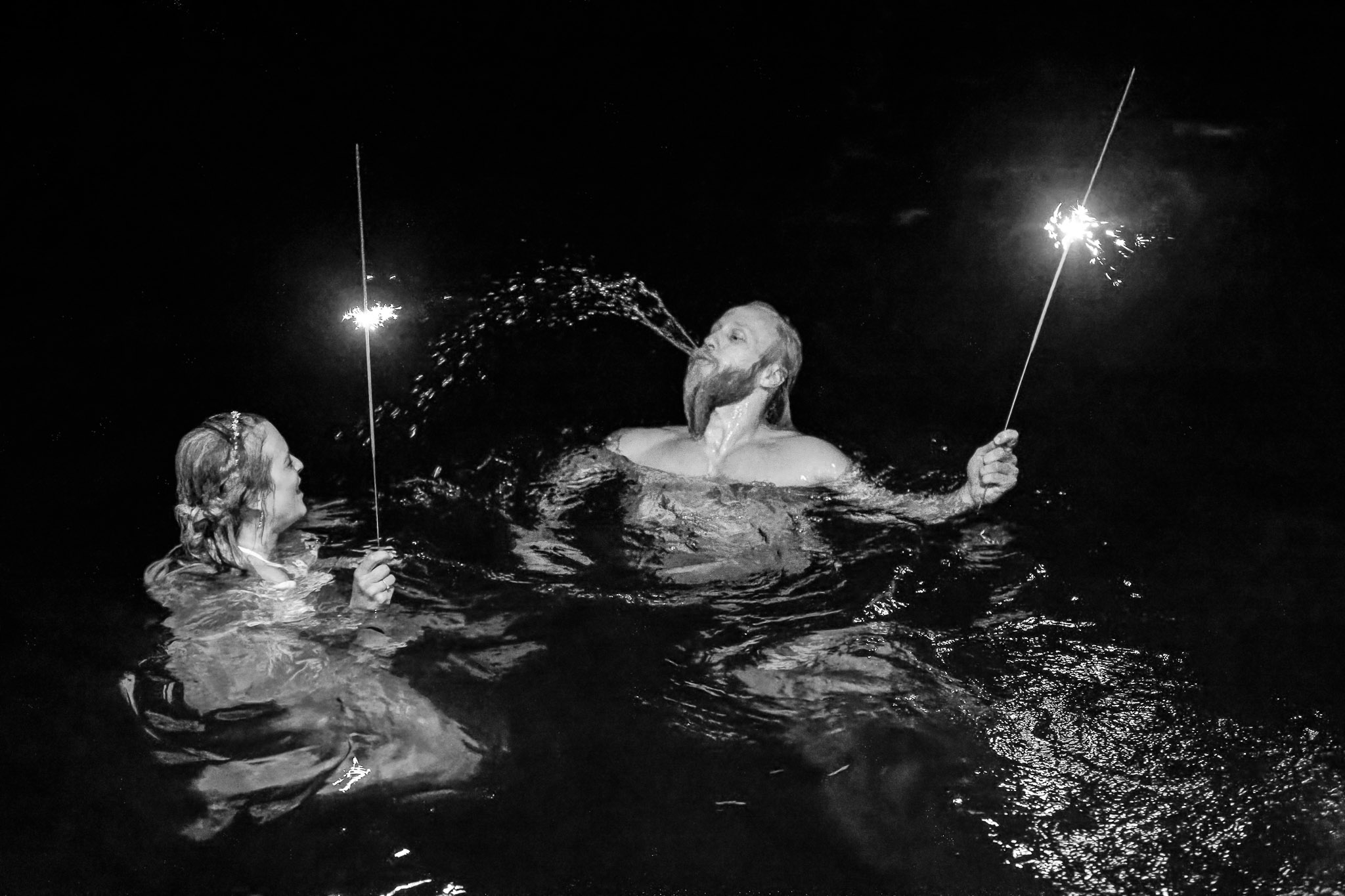 Bride and Groom Jump in Water with Sparklers After Reception