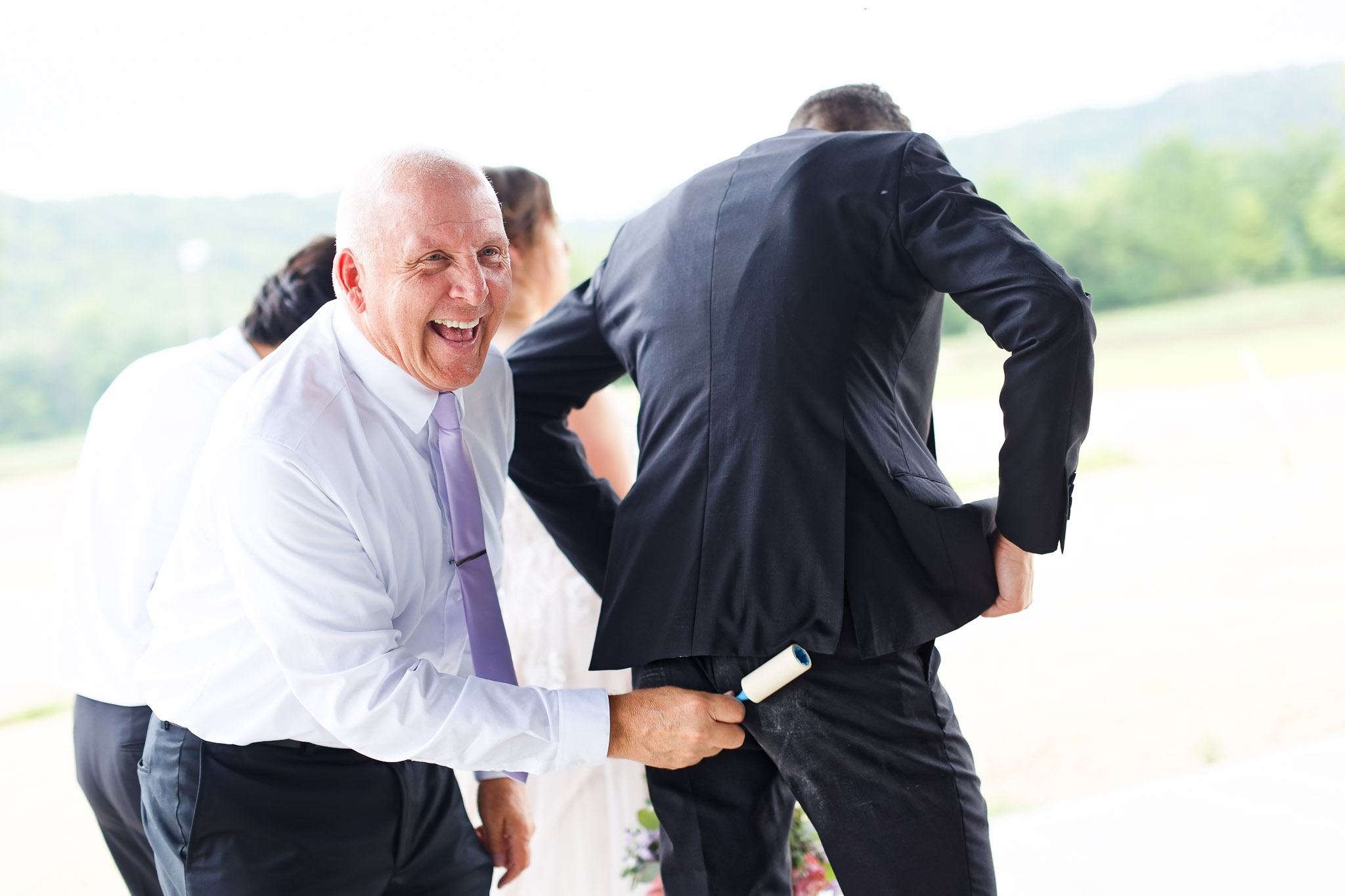 Father Cleaning Groom's Suit with Lint Roller - Welch Village We