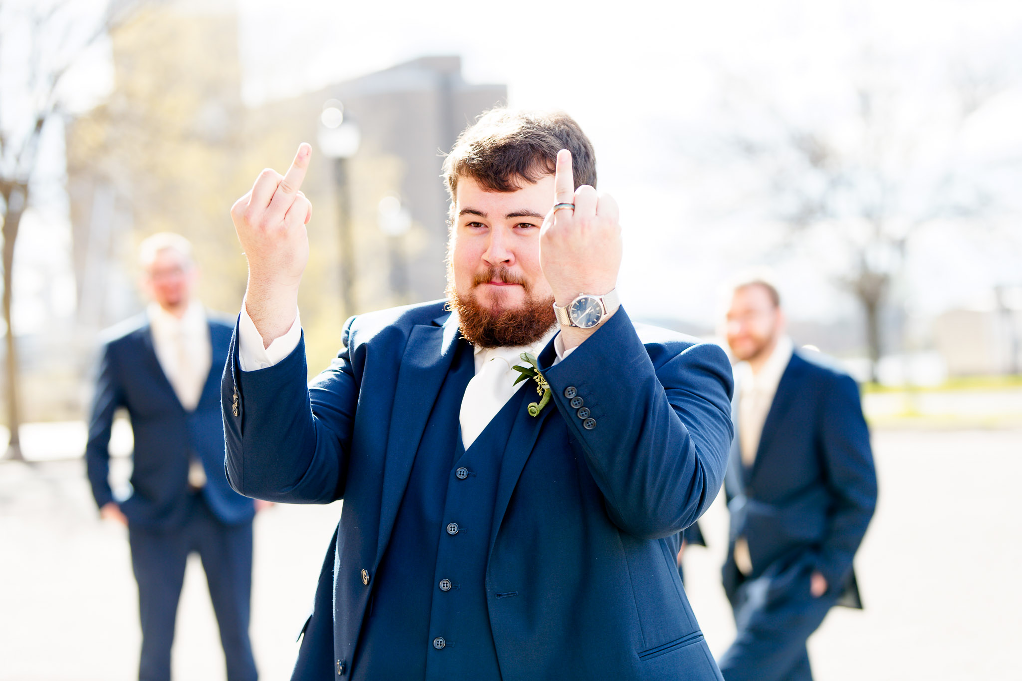 Groom Shows Wedding Ring in Playful Gesture During Reception