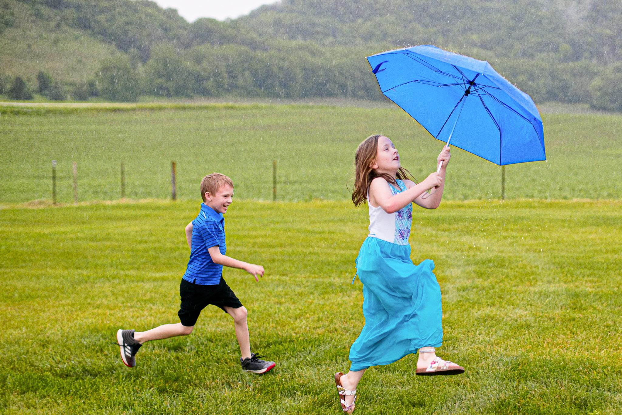 Kids Running with Umbrella in Rain at Wedding Reception