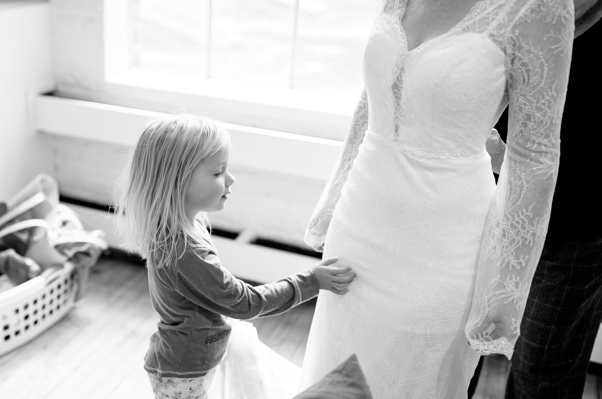 Flower Girl Touching Bride's Dress During Wedding Preparations