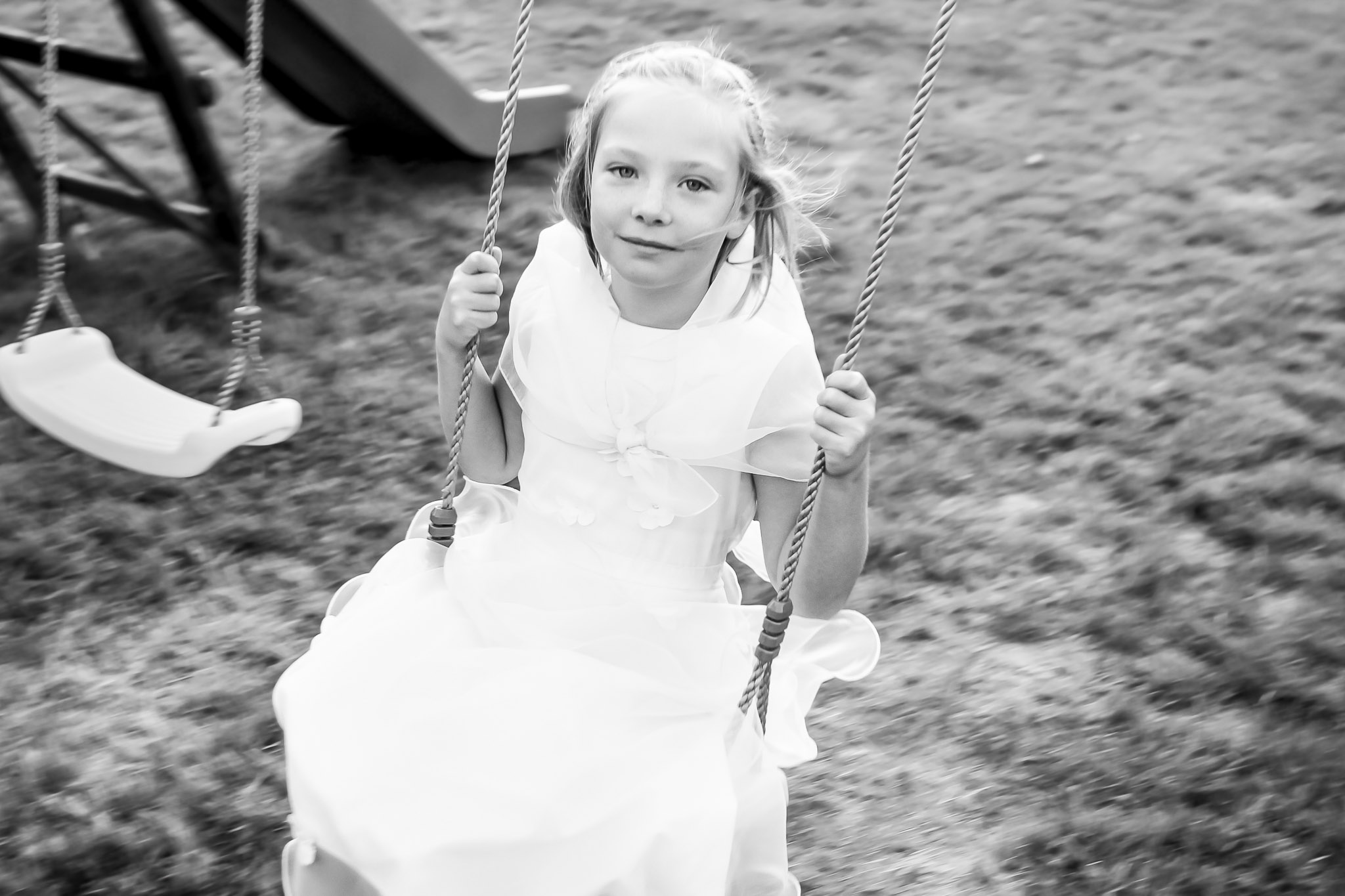 Flower Girl Playing on Swing During Wedding Reception