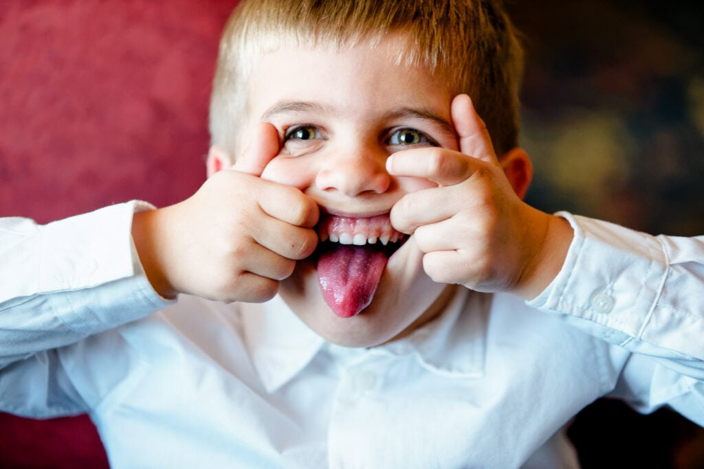 Child Making Silly Face at Wedding Reception