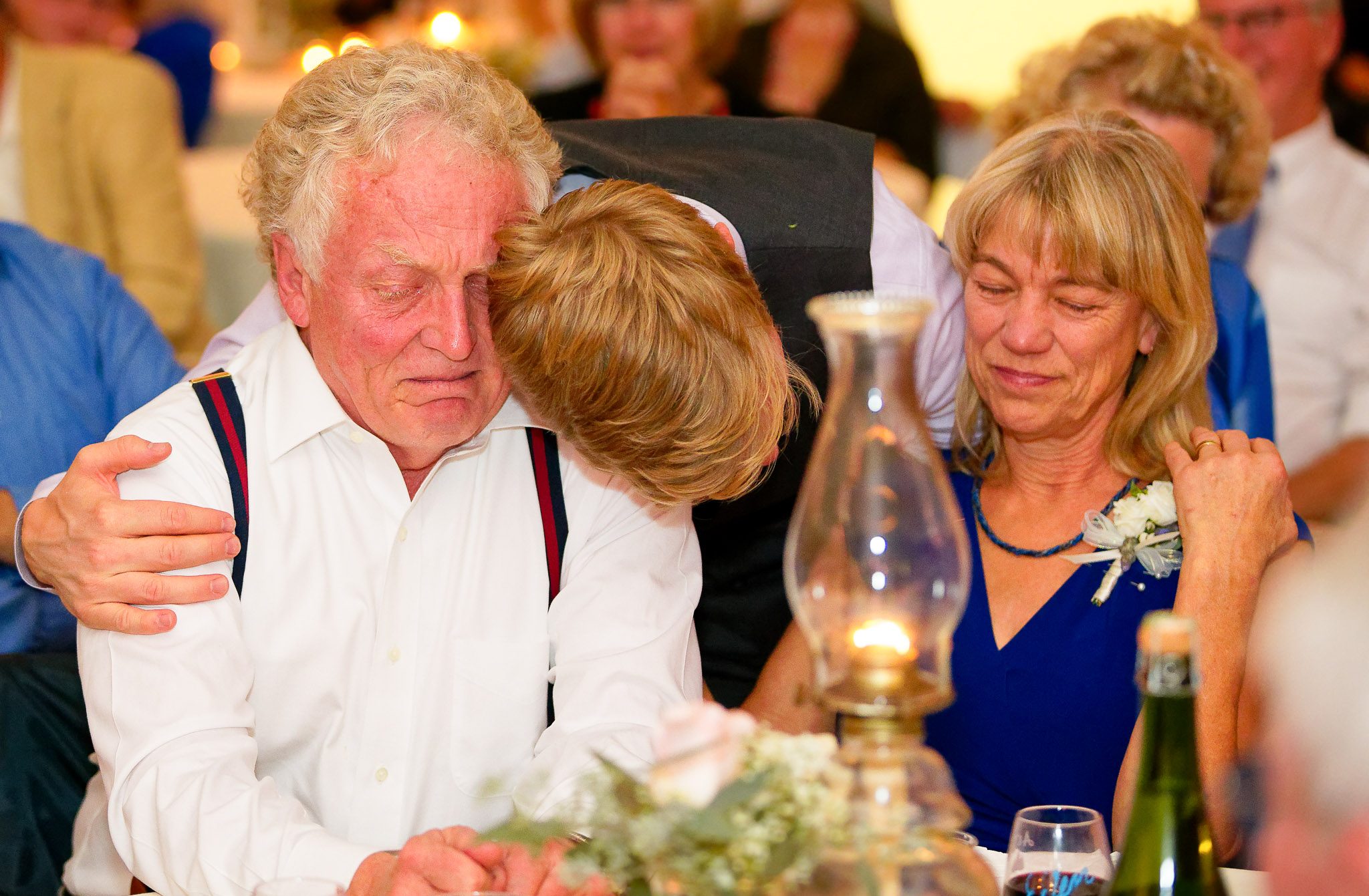 Groom Embracing Parents at Wedding Reception