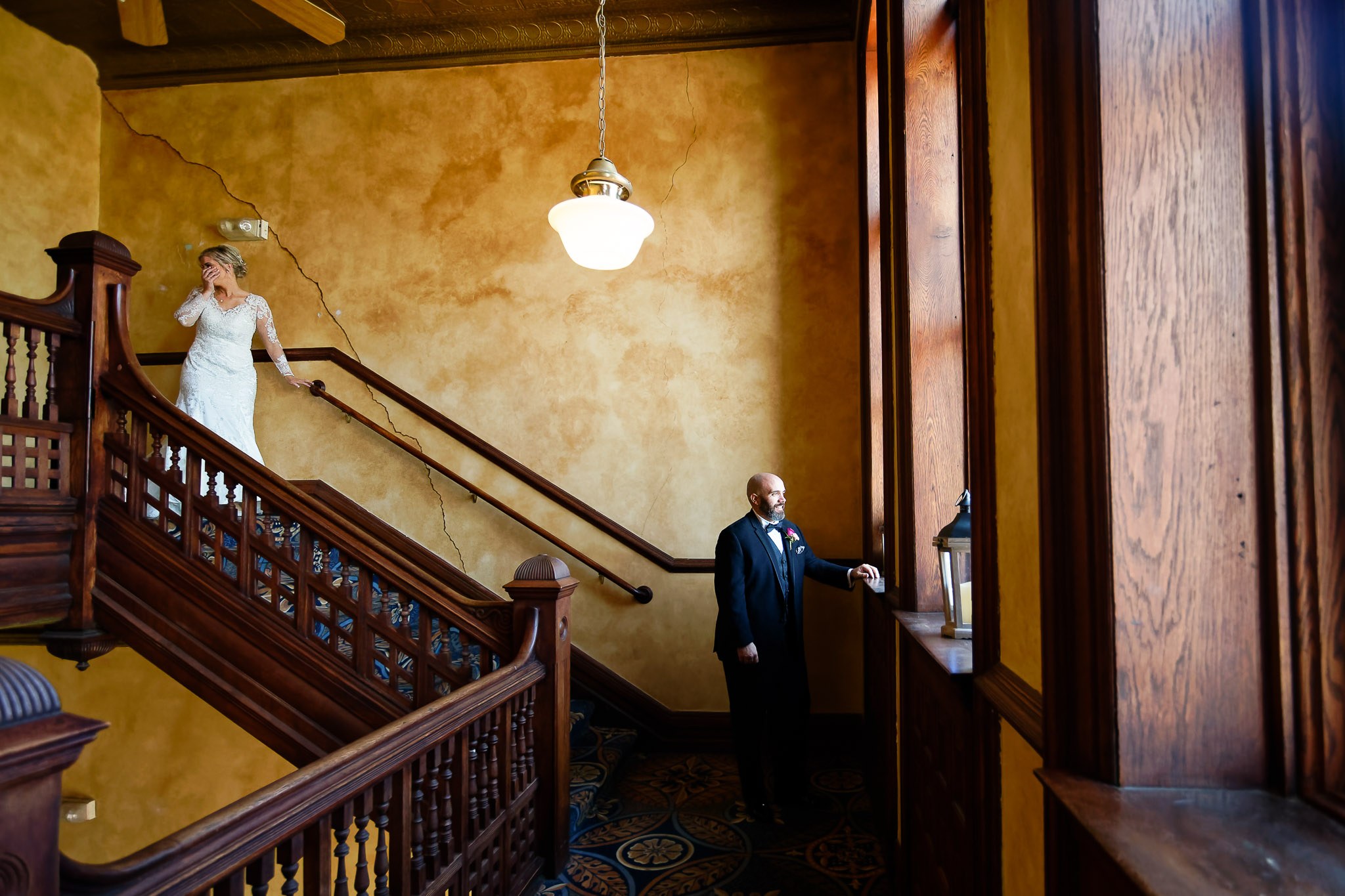 Bride Pauses on Staircase During First Look with Groom