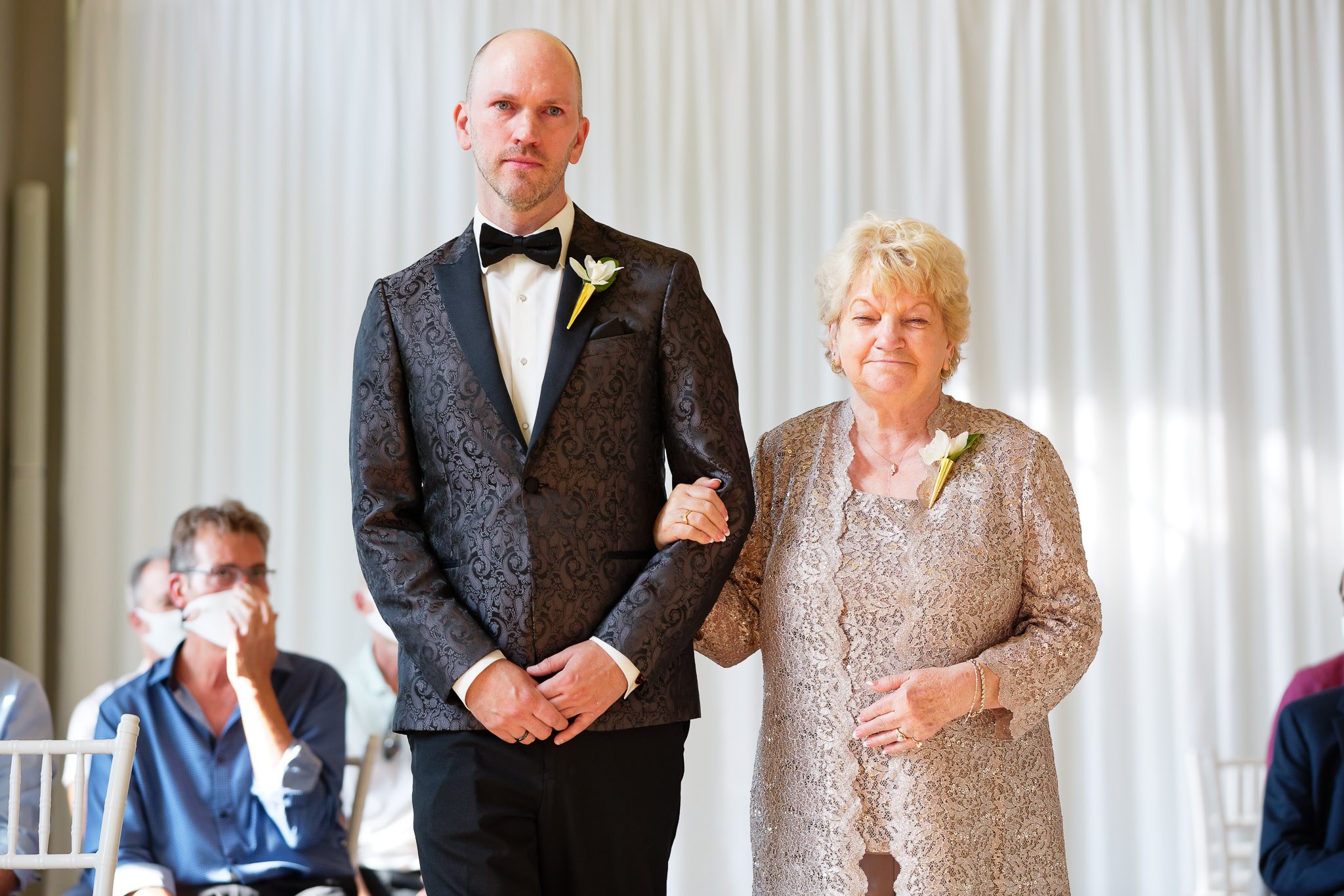 Groom Cries Walking Down Aisle with Mother at Wedding